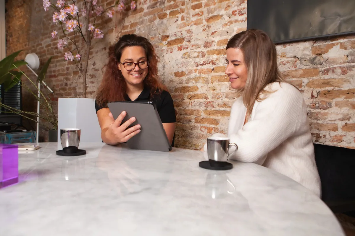 Energieadviseur bespreekt energiebesparende maatregelen met huiseigenaar tijdens huisbezoek aan tafel.